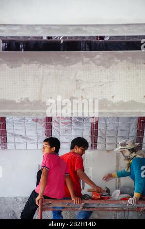 MAY 8, 2010 Bangkok, Thailand - Local poor young Asian building construction labours working and some sitting in construction site Stock Photo