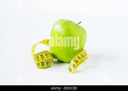 green apple with measuring tape on a white background Stock Photo