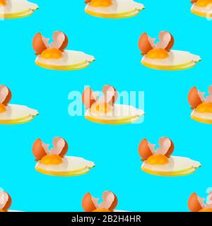 Seamless pattern of raw eggs with yellow yolk on blue background isolated, broken brown egg shell repeating ornament, Easter banner, paschal print Stock Photo