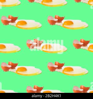 Seamless pattern of raw eggs with yellow yolk on green background isolated, broken brown egg shell repeating ornament, Easter banner, paschal print Stock Photo