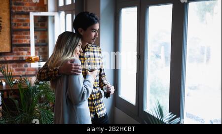 Young couple looking through the window Stock Photo
