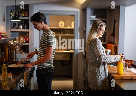 Young couple cooking together at home