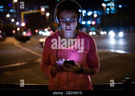 Front view woman using her phone before running Stock Photo
