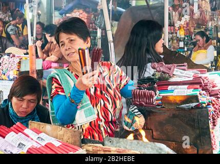 Manila, Philippines: Group of women selling colourful candles in stalls around famous landmark Quiapo church as form of livelihood Stock Photo