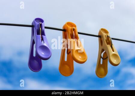 Linen clothespins on the wire for drying clothes against the sky Stock Photo