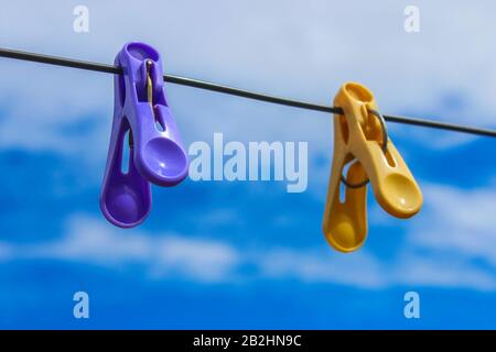 Linen clothespins on the wire for drying clothes against the sky Stock Photo