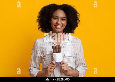 Premium Photo | Image of an emotional beautiful young woman posing isolated  over purple wall wall holding chocolate.