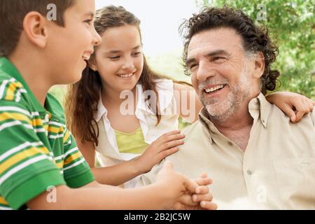 Portrait of senior man having fun having fun with grand daughter and grand son Stock Photo