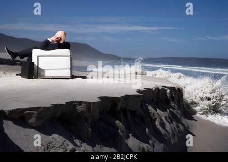 Business man using mobile phone sitting on sofa on beach back view Stock Photo
