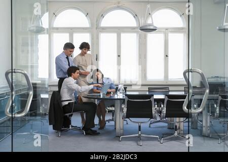 Four business people using laptop in office Stock Photo