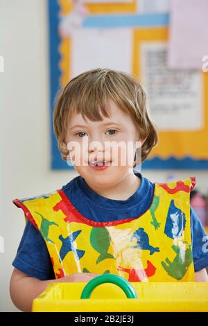 Portrait of boy (5-6) with Down syndrome in kindergarten Stock Photo