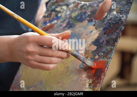 Close-up of woman's hand with brush and palette Stock Photo