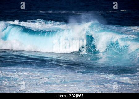 rolling breaking blue waves crashing in the sea off the shoreline of Lanzarote canary islands spain Stock Photo