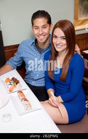 Portrait of a happy couple with Japanese cuisine Stock Photo