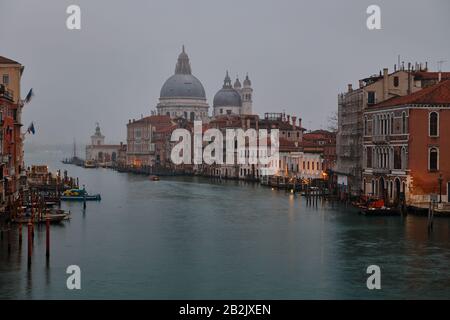 Venice, Italy - February 17 2020 : View of the Grand Canal of Venice Italy and the Basilica Santa Maria della Salute on morning fog Stock Photo