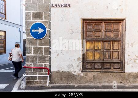 One way traffic sign on old wall next to wooden shuttered window in La Vera street in Guia de Isora, Tenerife, Canary Islands, Spain Stock Photo