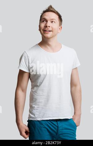 Young Caucasian man in casuals looking away against white background Stock Photo