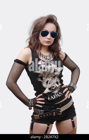 Portrait of gothic young woman with hands on hips over white background Stock Photo