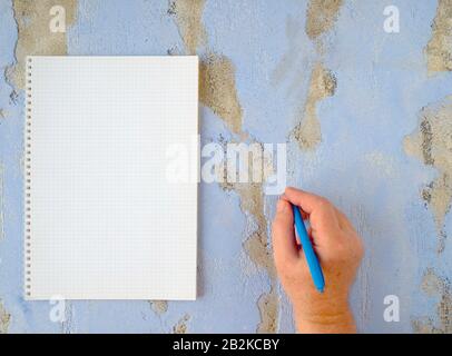 Ukraine. 3rd Mar, 2020. In this photo illustration, a hand of a person holds a blue pen while writing on a blue surface. Credit: Igor Golovniov/SOPA Images/ZUMA Wire/Alamy Live News Stock Photo