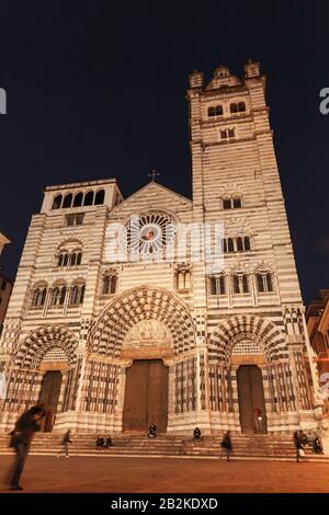 Genoa Cathedral or Cattedrale Metropolitana di San Lorenzo. Night street view of old Genova with unrecognizable walking people Stock Photo