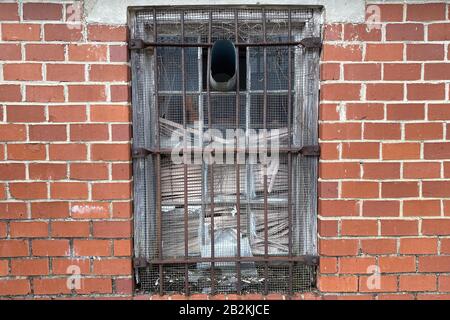 a rusty old steel rod window on a vintage red brick building wall Stock Photo