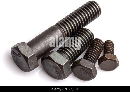 Four black hexagonal head bolts of different lengths are arranged diagonally on a plain white background. The bolts feature threaded shafts and hexagonal heads, with visible markings such as 'GB' on Stock Photo