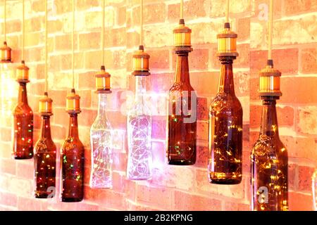 Bottle shape Energy efficient wall lamp. Illuminated wall lamp mounted on the wall at the exhibition. Stock Photo