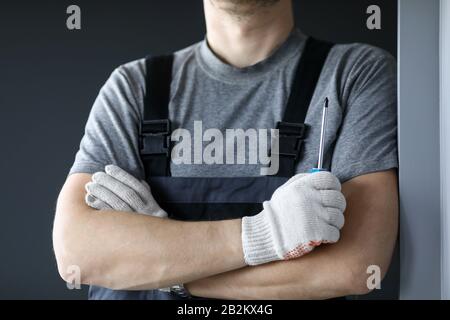 Repairman standing in empty flat and holding screwdriver in hands Stock Photo