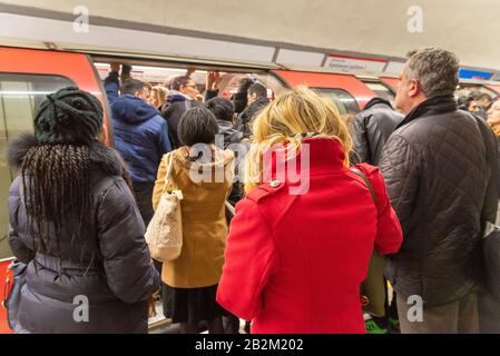 Commuters trying to board overcrowded Central Line London Underground carriage during the morning rush hour, UK Stock Photo