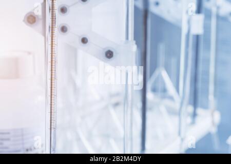 Measured scale for analyzing the quality of a liquid in a chemical laboratory, an instrument with equipment made of glass with blue liquid. Chemical e Stock Photo