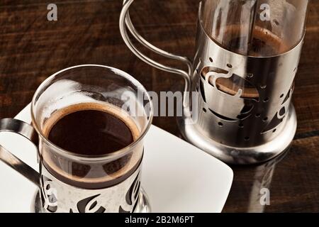 Luxury Coffee Cup Served Along With Screen Against Heavy Polished Wooden Table Stock Photo