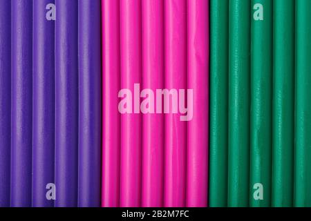 Soft clay from briquettes of violet, magenta and green for modeling. Plastic colorful material for children art education. Close-up full screen, textu Stock Photo