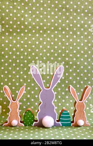 Three wooden Easter bunnies from behind with painted decoration. Stock Photo
