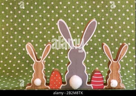Three wooden Easter bunnies from behind with painted decoration. Stock Photo