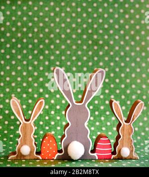 Three wooden Easter bunnies from behind with painted decoration. Stock Photo