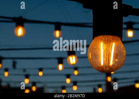 Light bulbs on the evening blue sky. Stock Photo