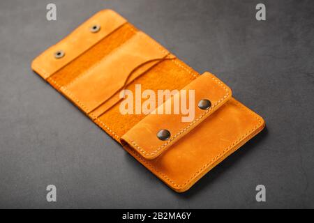 Brown purse, wallet made of genuine leather Nubuck on a dark background. Elements of leather craft products handmade. Handmade rivets and seam Close-u Stock Photo