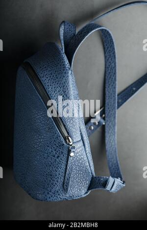 Blue backpack made of genuine leather on a dark background, handmade. Close up and in detail. Stock Photo