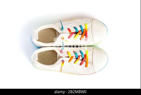 White sneakers with rainbow laces for the child on a isolated backgroun. Top view. Stock Photo