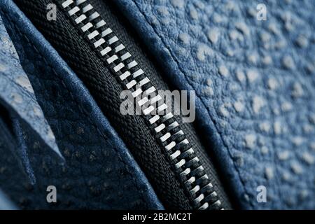Lock and buckle close-up, elements of a blue backpack made of genuine leather on a dark background, handmade. Macro Stock Photo