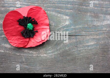 USA Memorial Day concept of red remembrance poppy made from fabric on dark vintage distressed wooden background, with copy space. Stock Photo