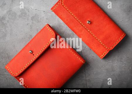 Set of two Wallets and organizer made of genuine red leather, handmade on a dark background. View from above Stock Photo