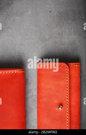 Set of two Wallets and organizer made of genuine red leather, handmade on a dark background. View from above Stock Photo