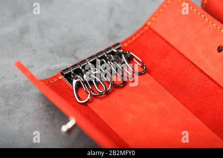 Handmade key holder made of genuine red leather on a dark background. Close-up Stock Photo
