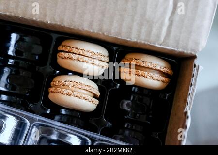 Macaroons in a cardboard box. Container for transportation of dessert. Stock Photo
