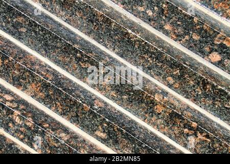 An abstract close up view of diagonal rows of black and gold granite. Stock Photo