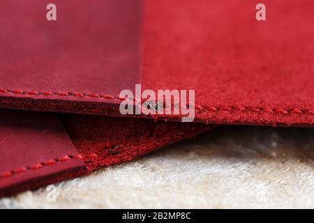 A leather craftsman works with leather. Sews leather goods. Making things handmade. Women's hands with a needle, thread, scissors and a blowtorch. Clo Stock Photo