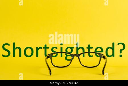 A Cocncept about shortsighted depicted with glasses and blurred text Stock Photo