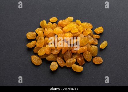 Dried yellow raisins on black background Stock Photo
