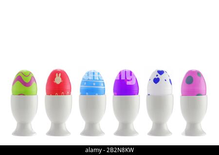 A set of six toy easter eggs in egg cups on white with clipping path Stock Photo